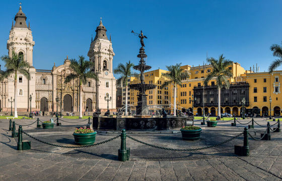 Historic Cathedral of Lima and Plaza de Armas with colonial architecture and palm trees.
